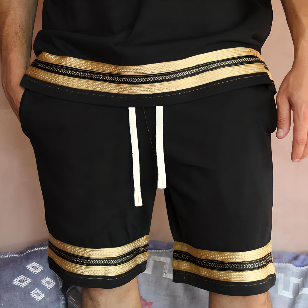 Front view of the Kaizo-Ku Moroccan Heritage Black and Gold Caftan Shorts, emphasizing the clean, elegant lines and the exquisite gold embroidery at the hem. The shorts offer a sophisticated look, blending traditional Moroccan design with modern streetwear.