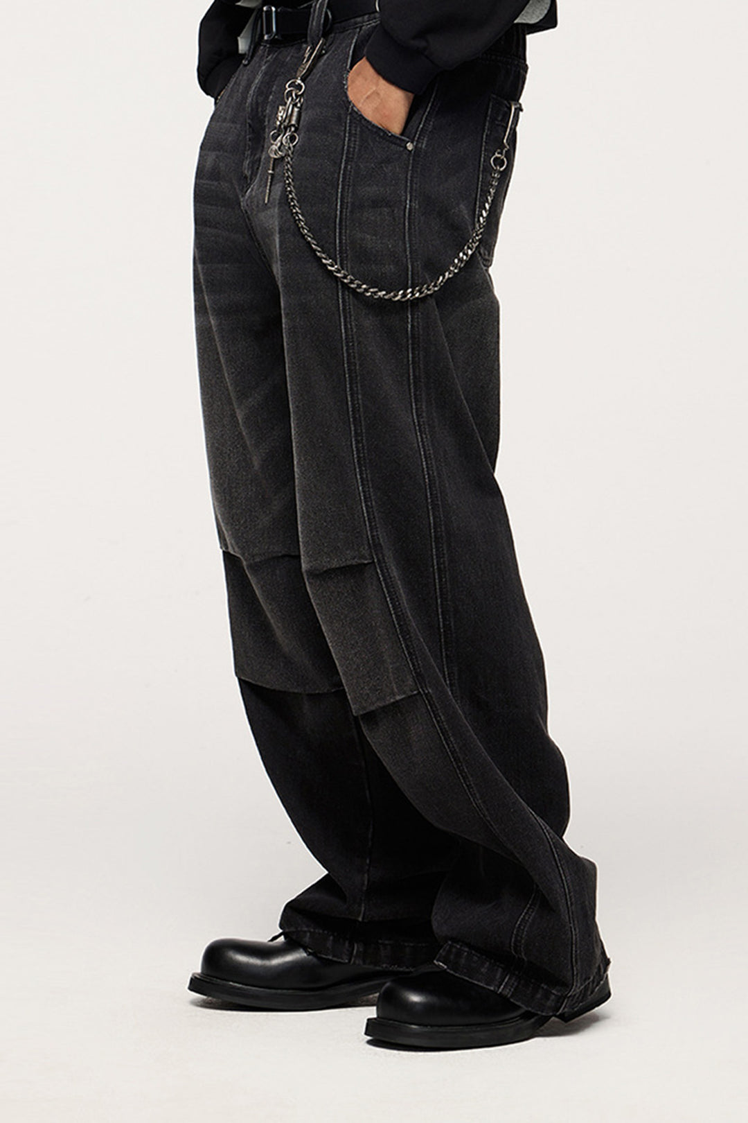 The black wide-leg jeans paired with silver chains and boots, creating a bold and edgy streetwear statement.

