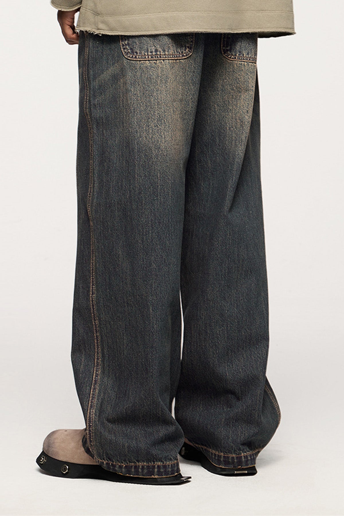 A rear view of the blue wide-leg jeans, featuring bold seam lines and a comfortable, loose fit for all-day wear.