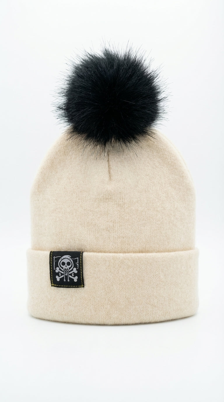 Bonnet d’hiver en cachemire beige premium avec pompon noir et étiquette Kaizo-Ku, accessoire haut de gamme pour l’hiver.