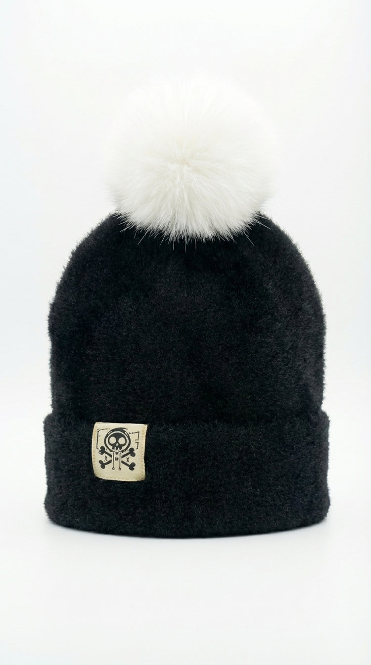 Bonnet d’hiver noir en cachemire présenté à plat, coupe structurée, matière chaude et finition haut de gamme.