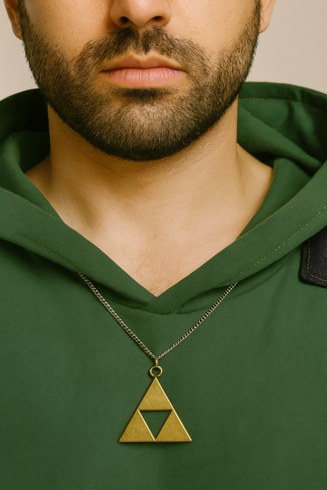 Gros plan sur le pendentif Triforce, pièce maîtresse de ce hoodie Zelda. Plus qu’un simple détail, ce bijou intégré au sweat relie directement le vêtement à l’univers culte de Link. Un accessoire mode et geek incontournable pour tout fan de Zelda.