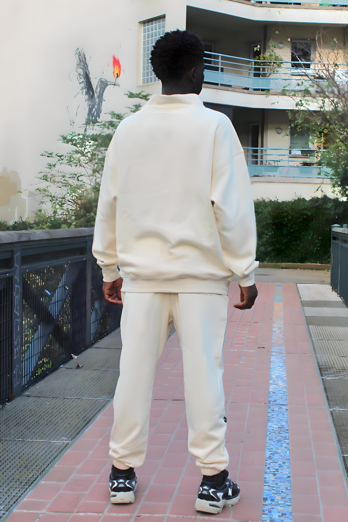 Back view of the beige Kaizo-Ku half-zipped sweatshirt on a male model, emphasizing the clean, understated design that Kaizo-Ku is known for. The relaxed fit offers comfort and ease of movement, making this sweatshirt a versatile addition to any wardrobe for a refined yet casual look.