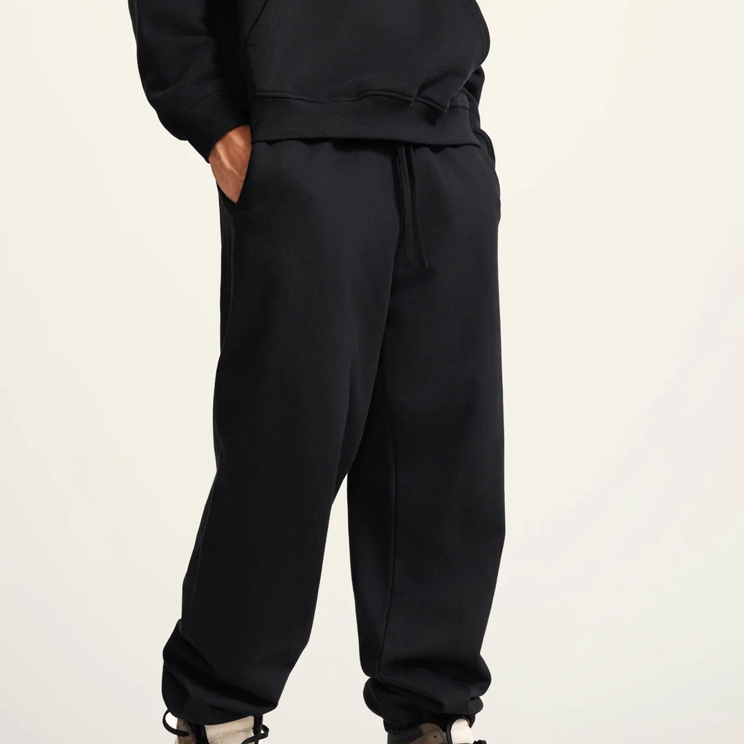 Side view of Kaizo-Ku joggers with gold logo on the thigh, showcasing modern urban style.