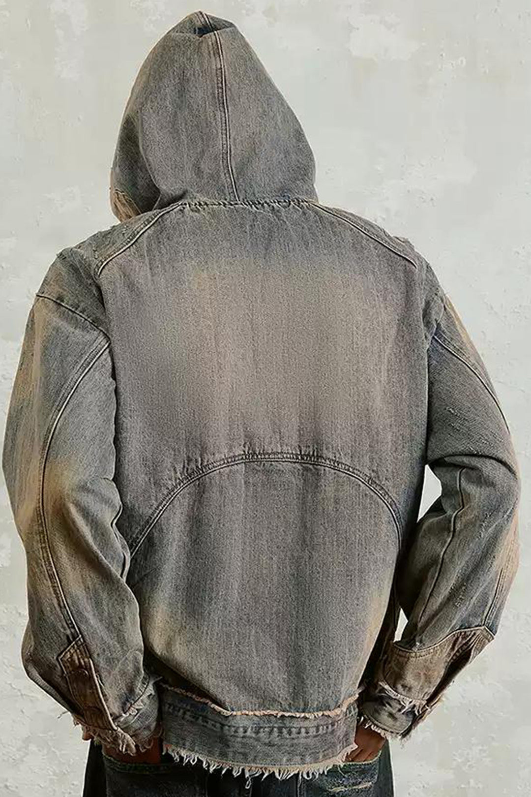 A back view of a model showcasing the Vintage Distressed Denim Hoodie with a relaxed fit and urban style, paired with camouflage cargo pants.