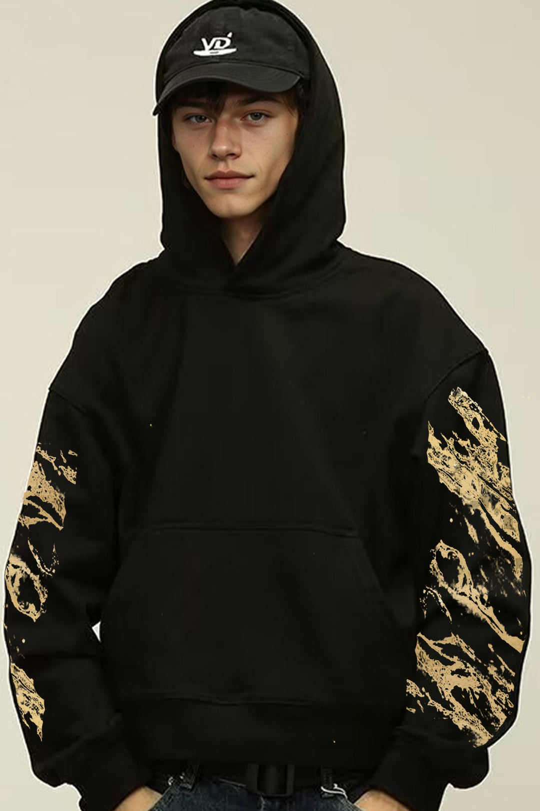 Model wearing the Kaizo-Ku Gold Splatter Skull Hoodie with bold gold sleeve details