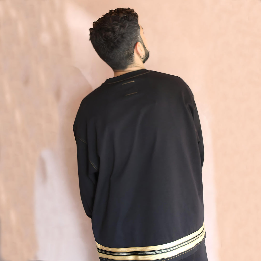 Back view of the t-shirt featuring a continuous design of gold embroidery, adding a touch of regal sophistication. The oversized cut ensures comfort and style, perfect for a statement piece in your collection.