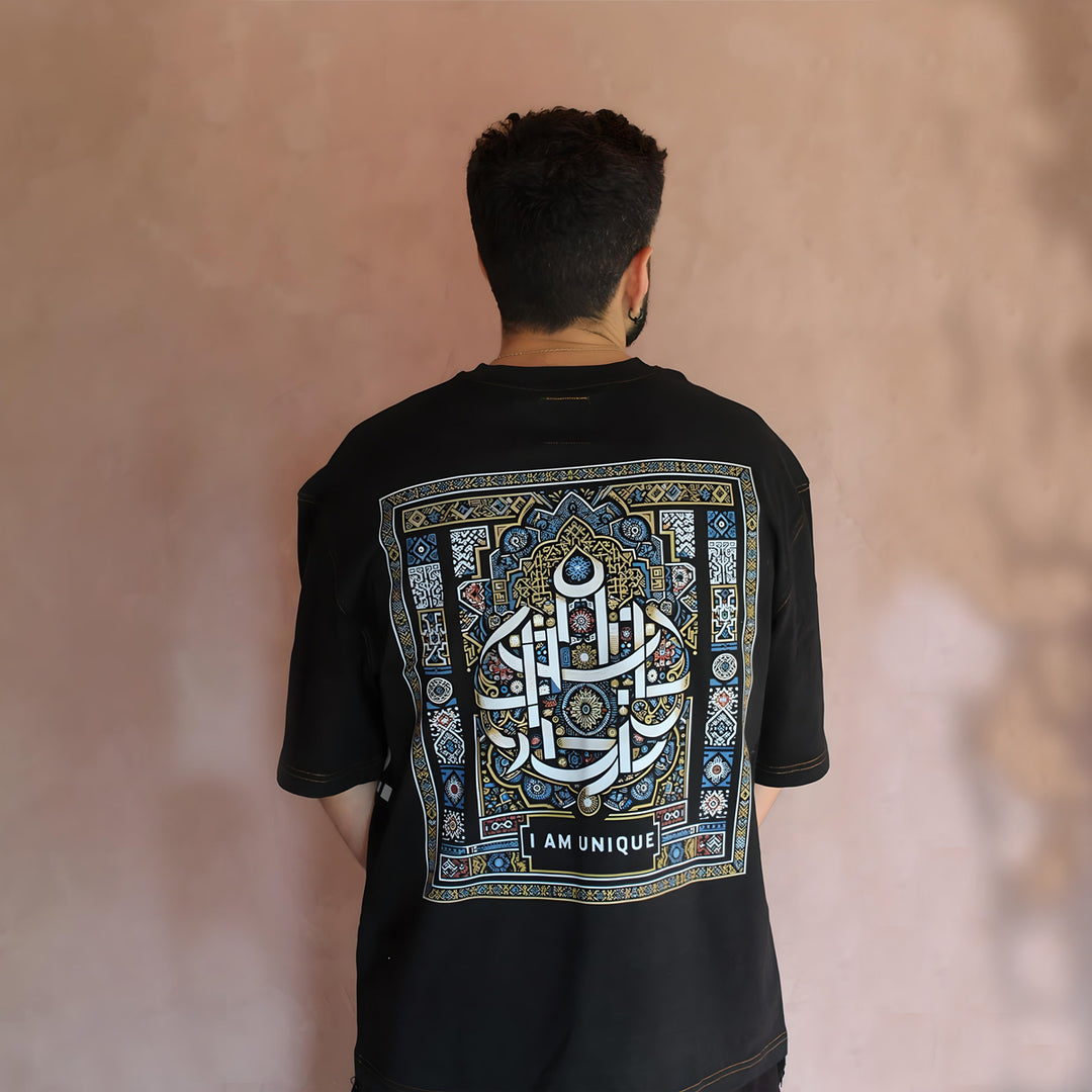 This image showcases the back of our oversized black t-shirt, featuring an intricate Moroccan-inspired traditional design. The bold "I AM UNIQUE" calligraphy is surrounded by detailed geometric patterns in blue and gold, highlighting the cultural essence of this unique piece.