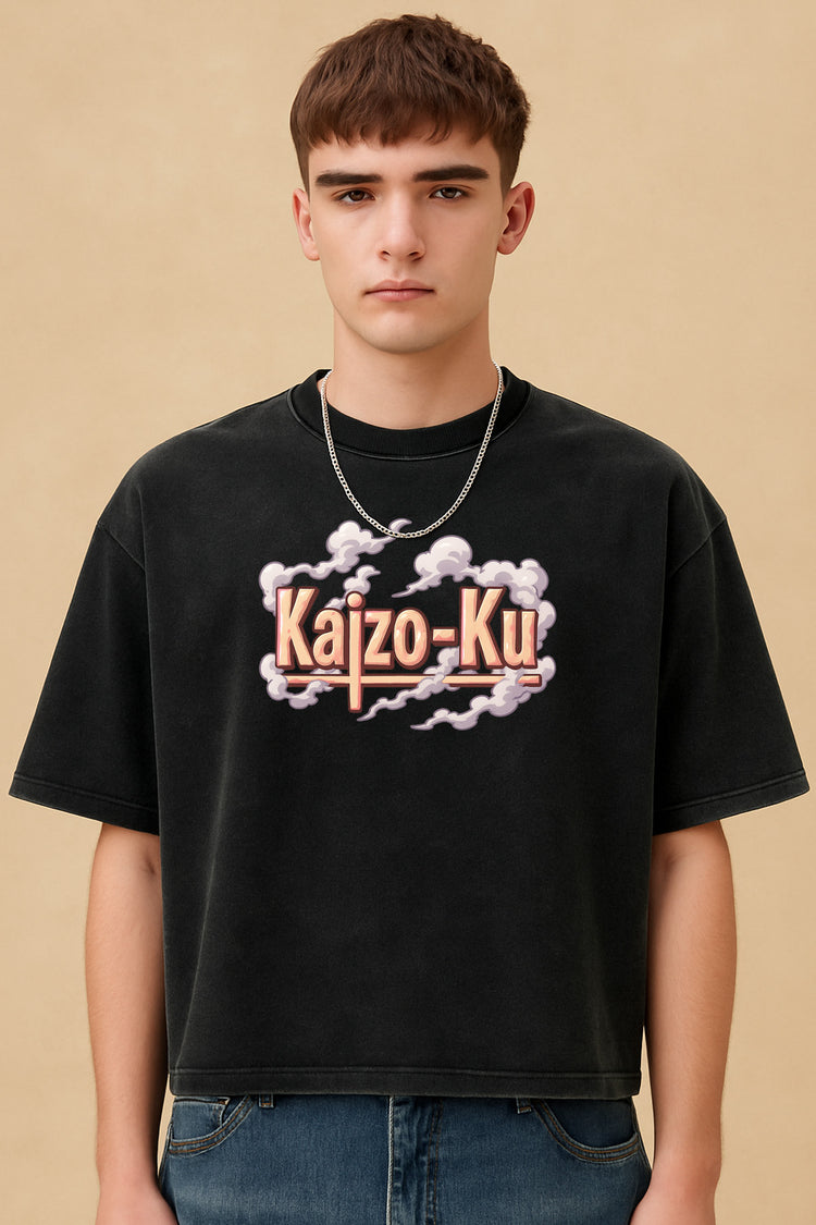 T-shirt Kaizo-Ku cropped oversize noir porté par un modèle, visuel frontal avec logo sérigraphié “Kaizo-Ku” en nuage rose – ambiance studio, fond beige doux.