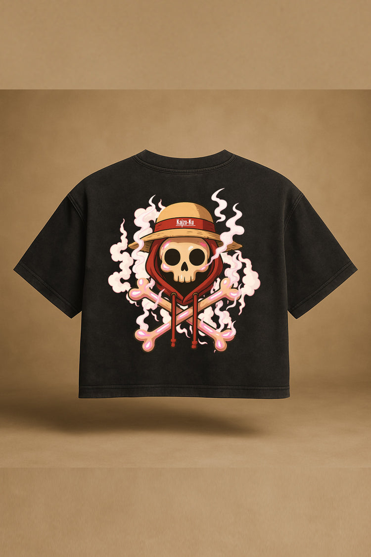 Vue à plat du t-shirt noir crop oversize Kaizo-Ku avec illustration exclusive “skull fumée et chapeau de paille” au dos, visuel inspiré de Luffy Gear 2 – rendu studio fond sable.