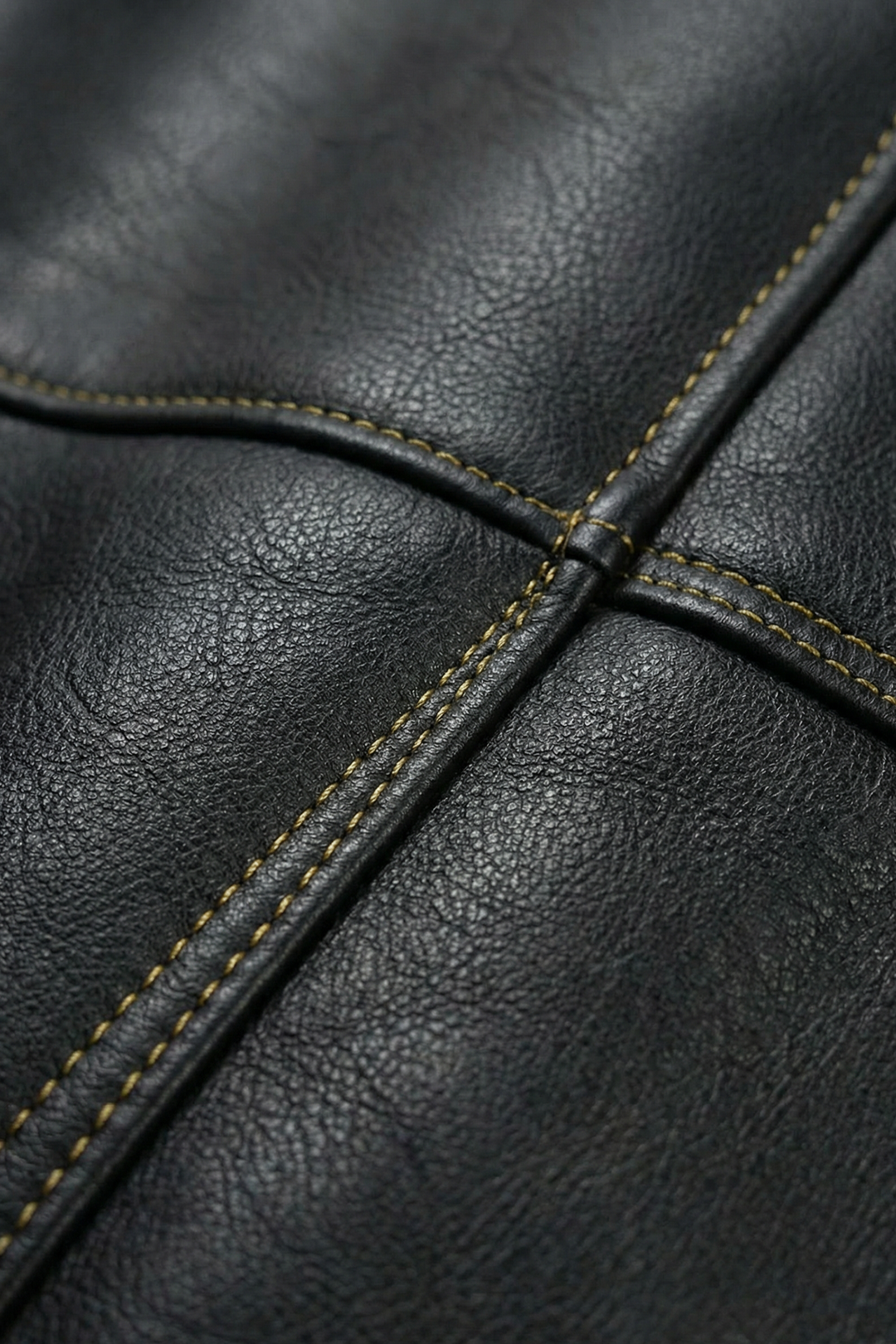 Gros plan sur le similicuir noir et les surpiqûres contrastées de la veste streetwear. Texture premium, finitions renforcées, style inspiré d’un univers pirate.