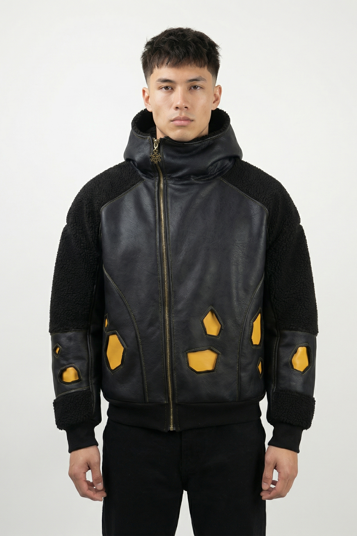 Modèle portant une veste streetwear noire inspirée d’un univers pirate, avec empiècements jaunes et capuche haute. Silhouette moderne et matériaux premium.