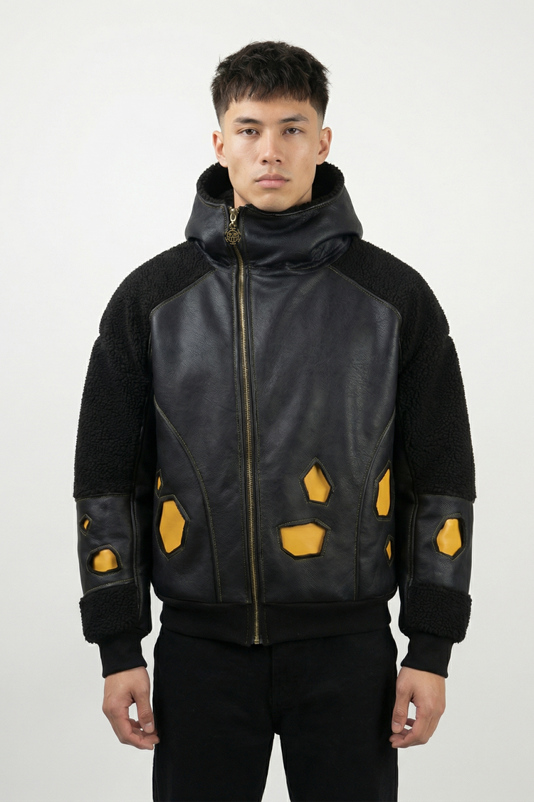 Modèle portant une veste streetwear noire inspirée d’un univers pirate, avec empiècements jaunes et capuche haute. Silhouette moderne et matériaux premium.