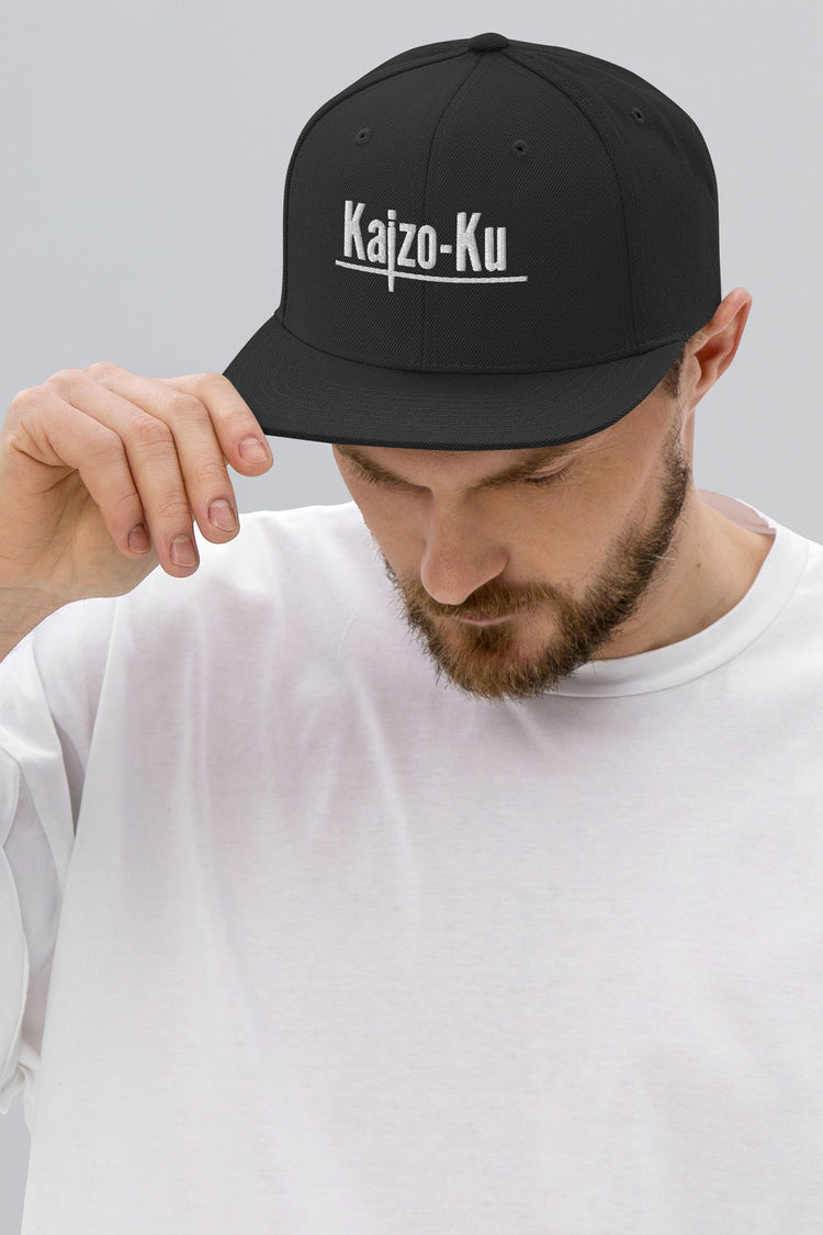 Side profile wore by a model of the Kaizo-Ku Classic Snapback in Black, highlighting the clean lines and iconic logo design for an urban, minimalist look