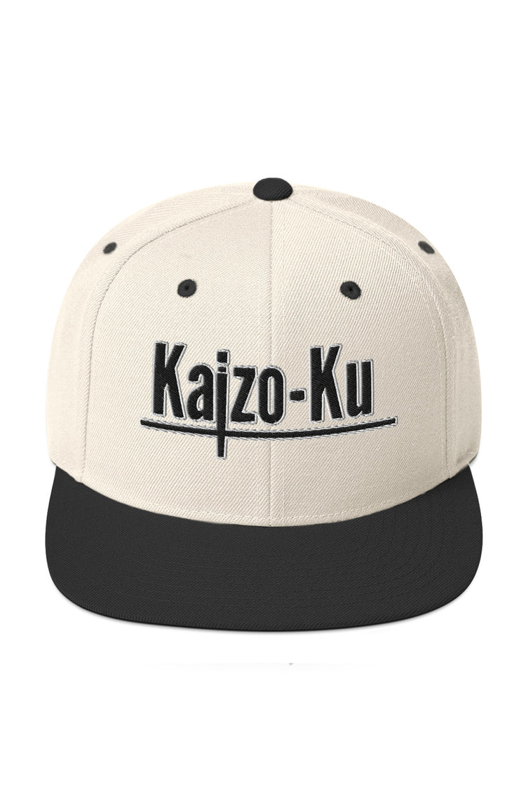 Cream and black Kaizo-Ku Snapback Cap with bold embroidered logo, front view showcasing premium design and quality stitching.