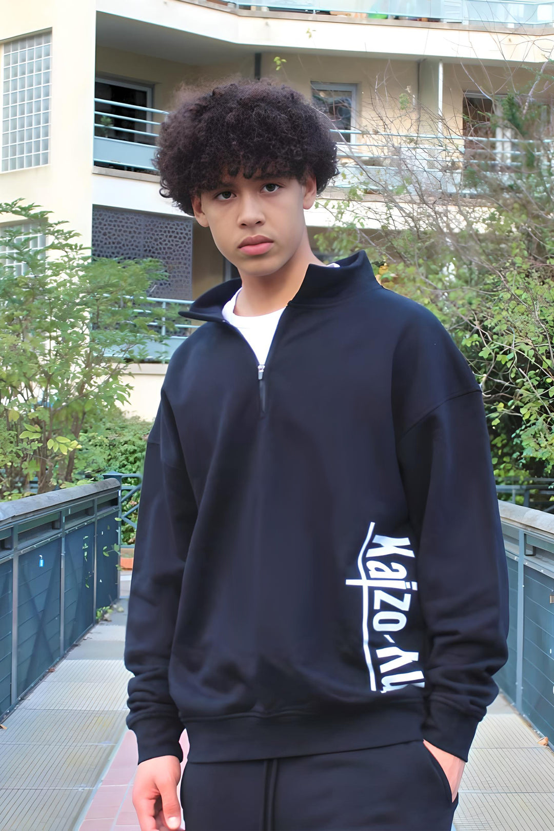 Model wearing the Kaizo-Ku black half-zipped sweatshirt, showcasing its clean, oversized fit from the front.