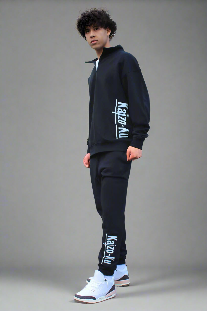 Full-body angled view of the model in the Kaizo-Ku black jogger, showcasing the jogger's relaxed, tapered fit within a modern, stylish ensemble.