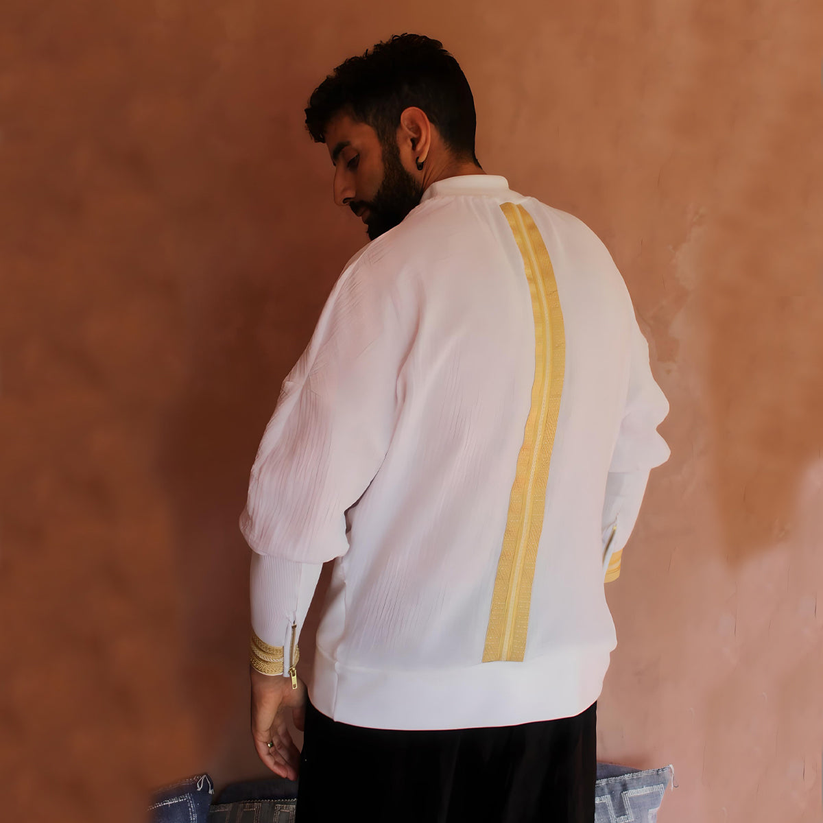 A side view from the left, emphasizing the oversized fit and how the gold detailing elegantly complements the white fabric, creating a harmonious blend of colors.