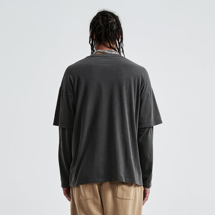 Back view of the model wearing the Kaizo-Ku oversized 2-in-1 t-shirt in Dark Grey. The design combines streetwear style with a relaxed, oversized fit.