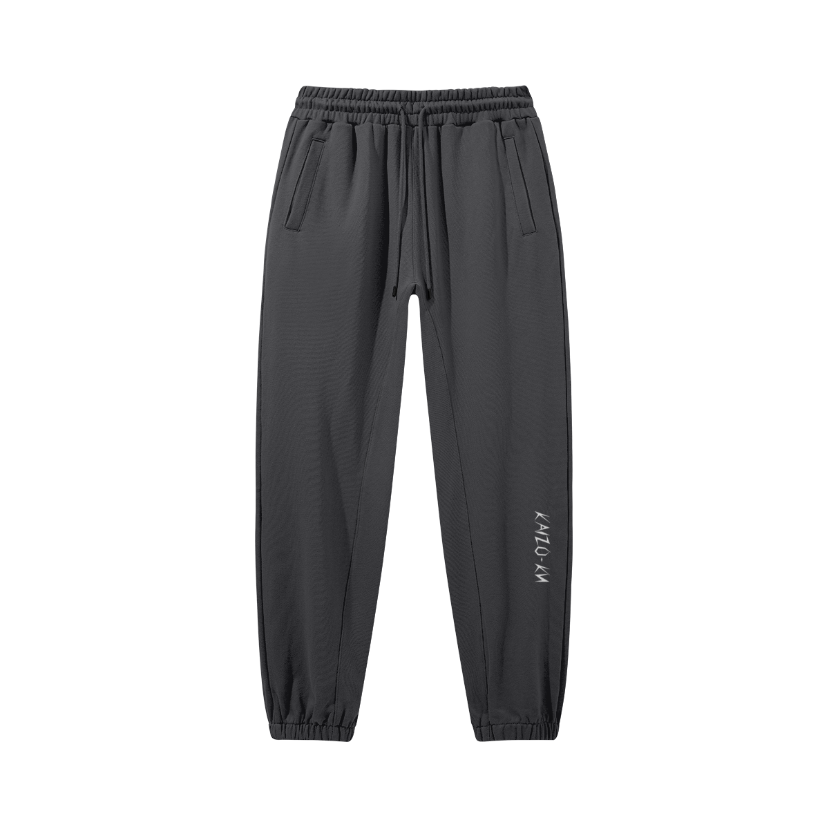 Flat front view of the Kaizo-Ku oversized jogger in Dark Grey, featuring the embroidered "Kaizo-Ku" logo on the left shin. Minimalistic and comfortable streetwear design.