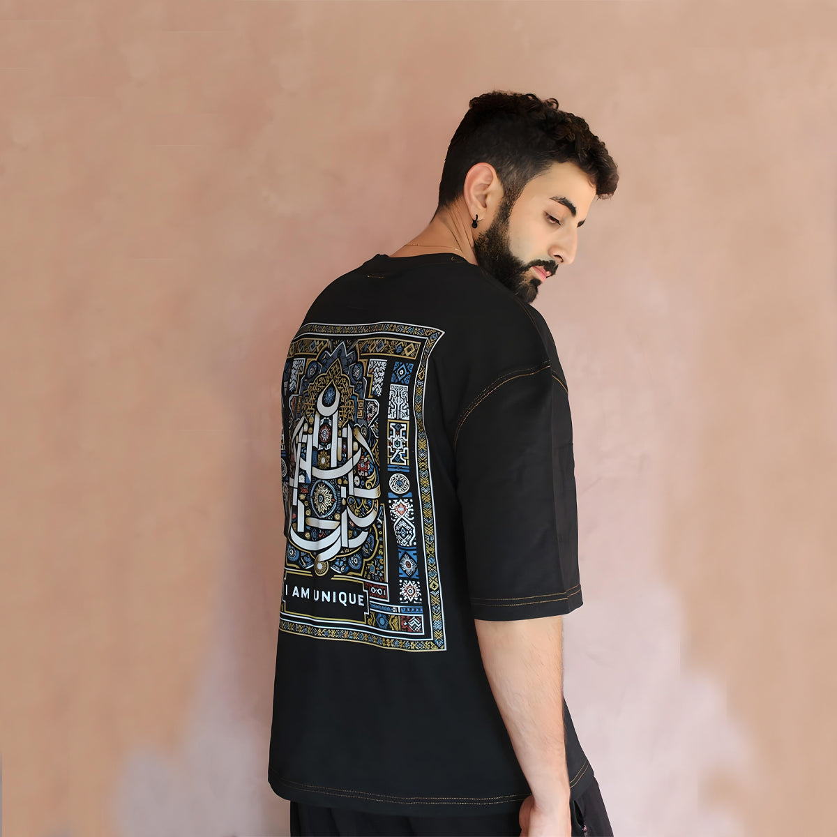 Model displaying the right-side back view of the oversized black t-shirt. The intricate details of the Moroccan-inspired design are clearly visible, adding an artistic touch to this comfortable streetwear piece.