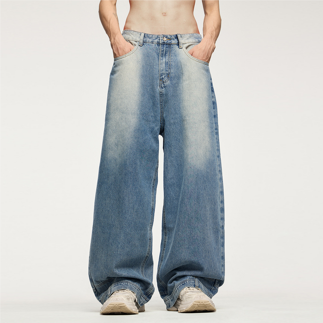 Front view of the Kaizo-Ku Upside Down Denim Jeans, worn by a model with a shirtless look. The wide-leg fit and inverted pocket details give these jeans a bold, avant-garde streetwear vibe.