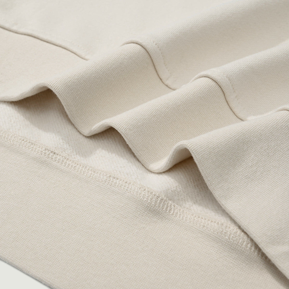 Close-up of the waist hem on the Kaizo-Ku zip collar sweater. Clean, minimalistic finish with high-quality fabric.