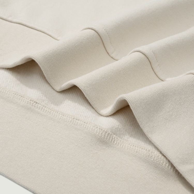 Close-up of the waist hem on the Kaizo-Ku zip collar sweater. Clean, minimalistic finish with high-quality fabric.